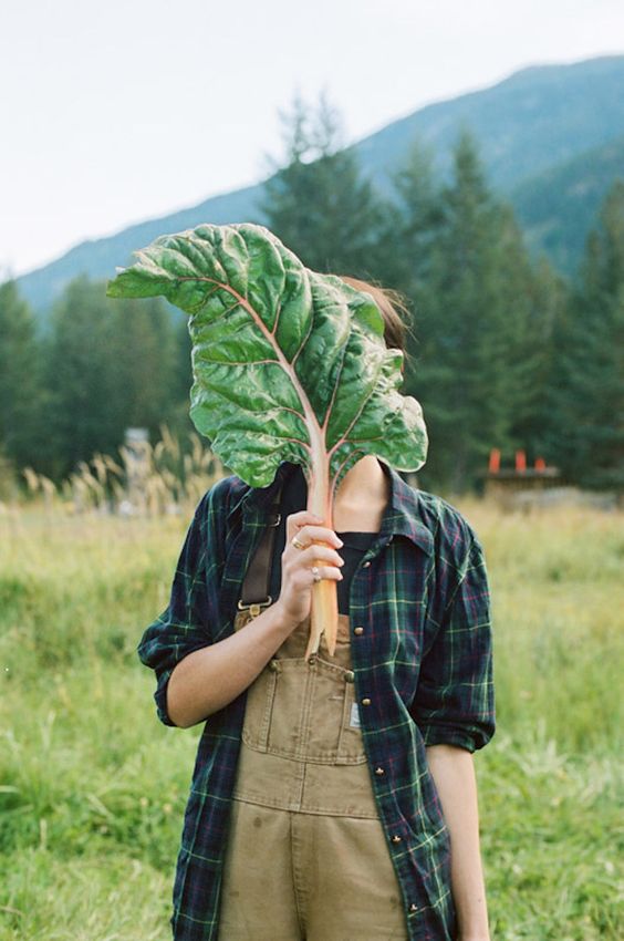 Buy Organic, farmer girl hiding face with large leaf